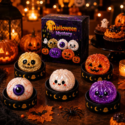 Set of five Halloween glitter pumpkin squishies on ghost-and-moon stands beside the Halloween Mystery gift box