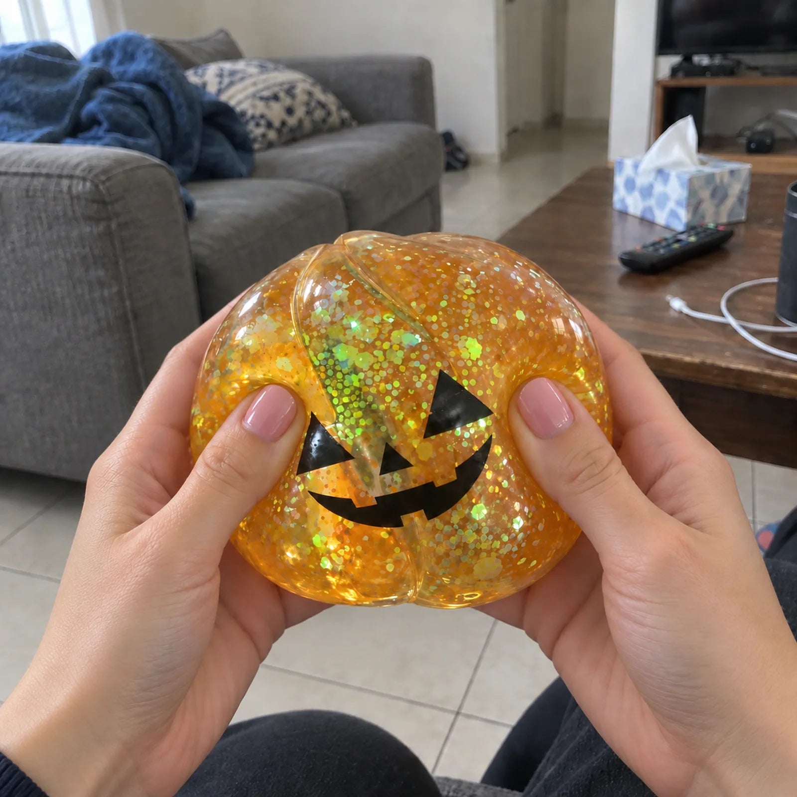 Hand gently squeezing a Calm Critter squishy beside an unsqueezed one